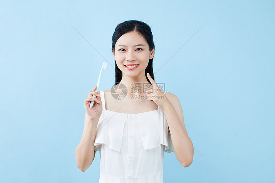 年轻美女拿牙刷展示图片