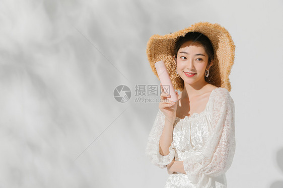 清澈阳光下的少女防晒用品展示图片