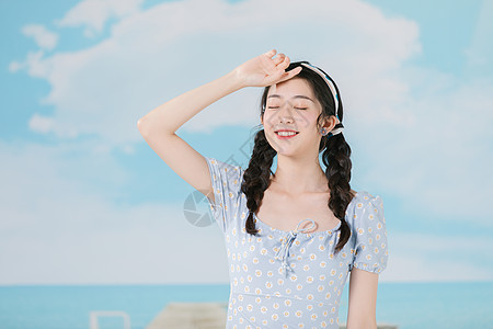 穿着蓝色碎花裙的海边夏日少女图片