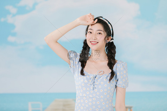 穿着蓝色碎花裙的海边夏日少女图片