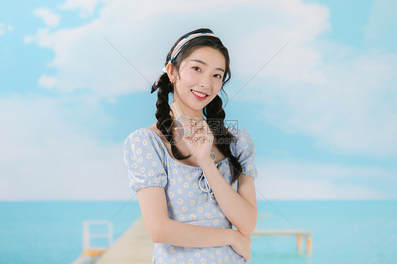 穿着蓝色碎花裙的甜美少女与防晒霜图片