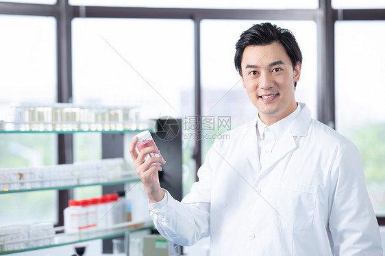 男性医疗科研人员手拿药品图片