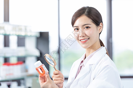 年轻女医疗科研人员用放大镜查验药品图片
