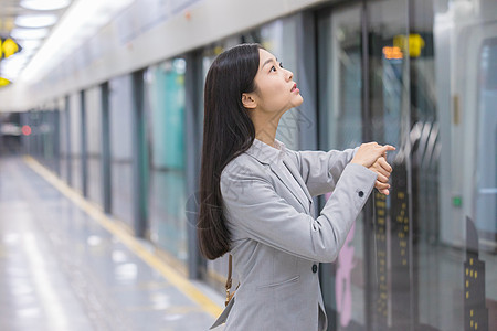 看手表着急等待地铁的商务女性高清图片