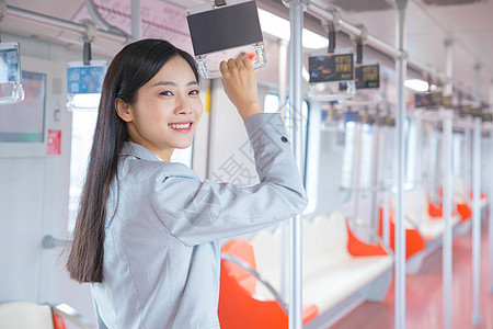 人图标乘坐地铁手握扶手的商务女性背景