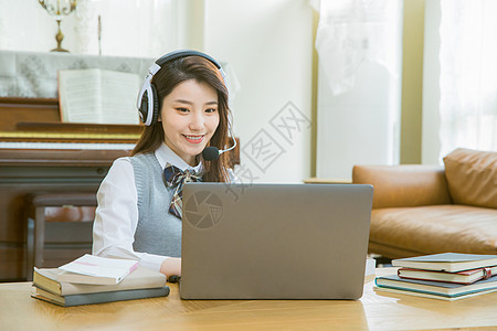 钢琴课程戴耳机的女学生上网课在线教育背景