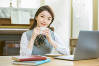 在客厅内喝咖啡学习的女大学生图片