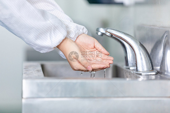 在水池前洗手的人图片