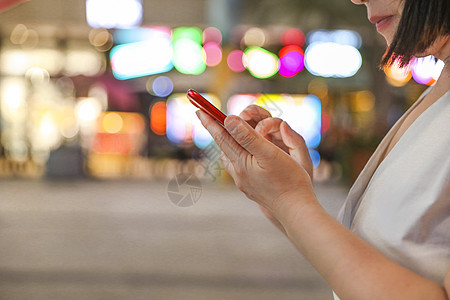 手机发烫女性夜晚看手机特写背景