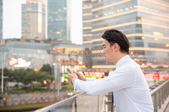 都市商务男性天桥上看手机图片