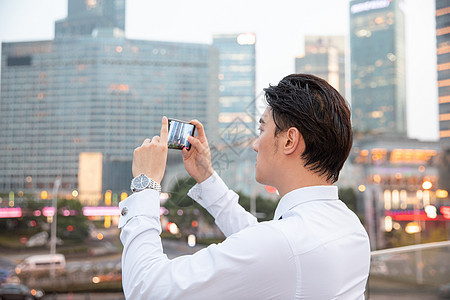 都市商务男性拿手机拍照图片