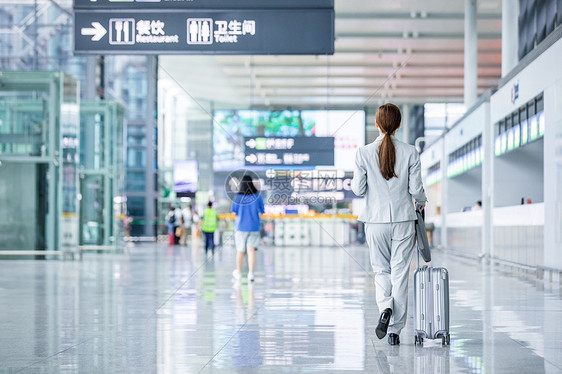 机场商务女性白领拖行李箱出行图片