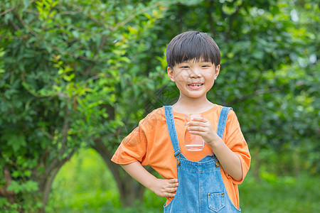 小男孩在户外喝水图片