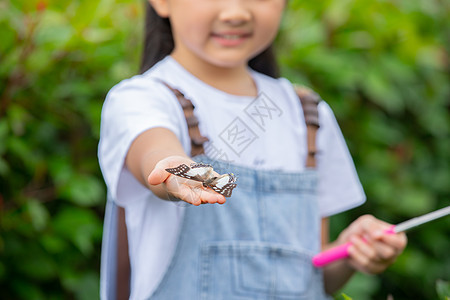 小女孩手捧蝴蝶特写图片