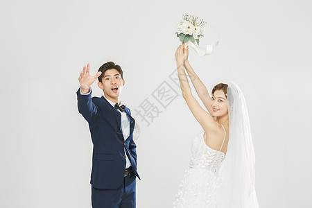 年轻情侣结婚时女生举起手捧花图片