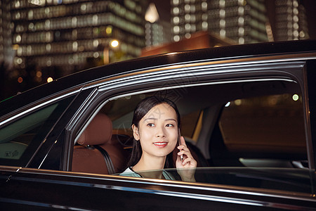 夜晚白领女性乘坐专车打电话图片