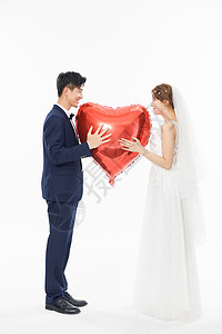 年轻情侣拿爱心拍摄婚纱照图片