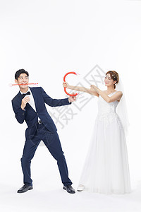 快乐的新娘和新郎拿着弓箭图片