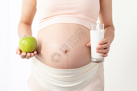 产妇饮食孕妇手拿苹果和牛奶背景