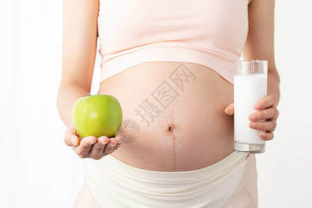 孕妇手拿苹果和牛奶高清图片