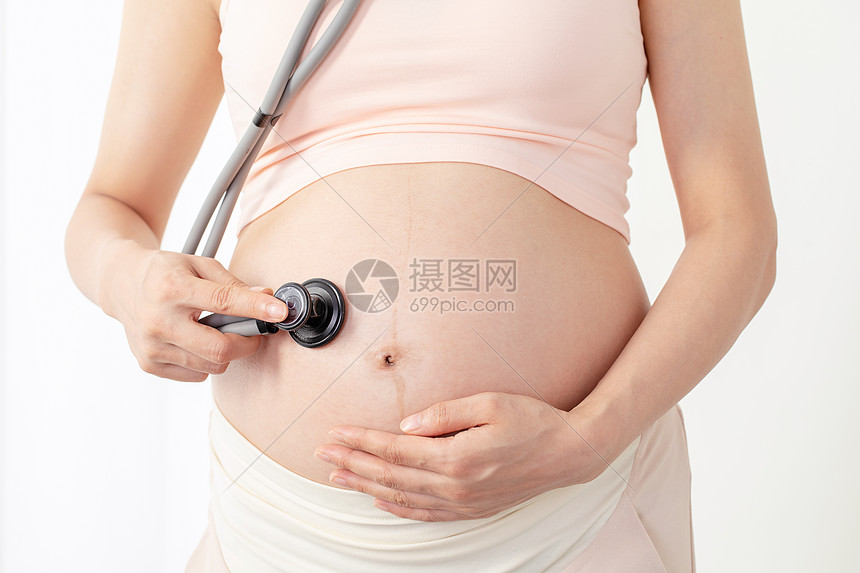 孕妇拿听诊器听肚子的胎动图片