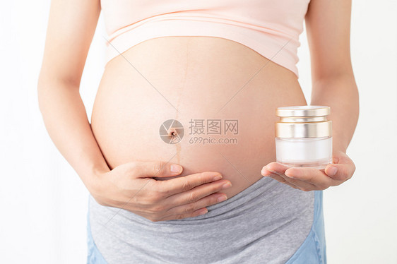 孕妇手拿润肤乳图片