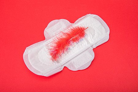 羽毛港币红色背景上的卫生巾背景
