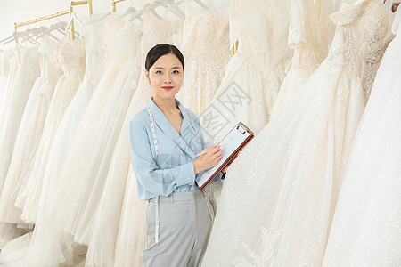 服装设计师记录婚纱尺码背景图片