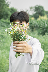 夏日男生田野拿花自拍背景图片