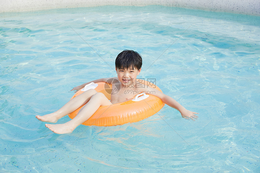 小男孩泳池里开心玩水