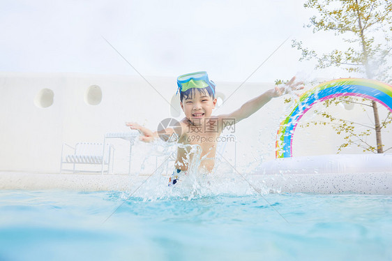 小男孩泳池里开心玩水图片