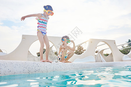 小男孩和小女孩站在泳池边跳水图片