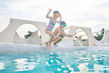 小男孩和小女孩站在泳池边跳水图片