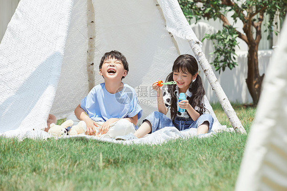小朋友坐在帐篷里吹泡泡玩图片