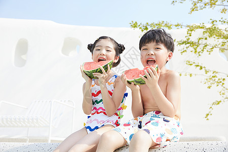 小男孩和小女孩坐在泳池边开心吃西瓜图片