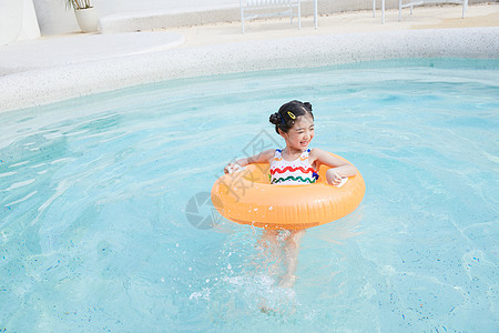 小孩游泳小女孩在泳池里面用游泳圈游泳背景