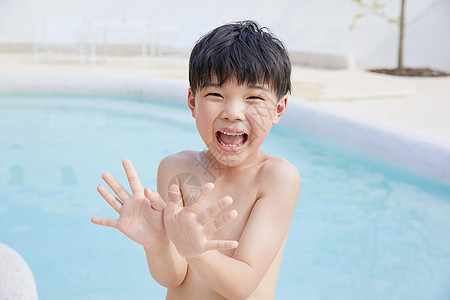 小男孩泳池里开心玩水图片