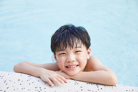 可爱小男孩趴在泳池边图片
