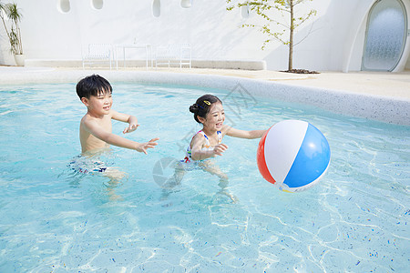 小男孩玩球小男孩和小女孩在泳池玩球背景