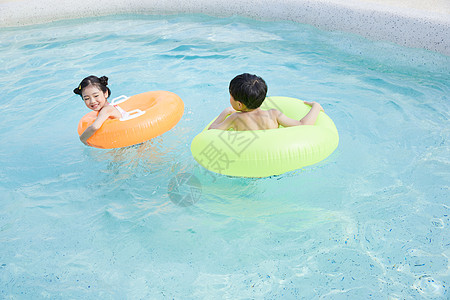 快乐儿童使用游泳圈在泳池玩耍图片