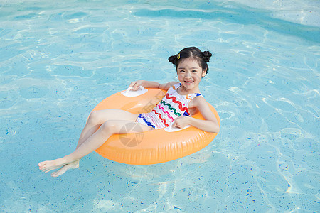 小女孩躺在游泳圈里面图片素材