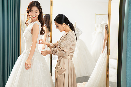 在镜子前试穿婚纱的准新娘图片