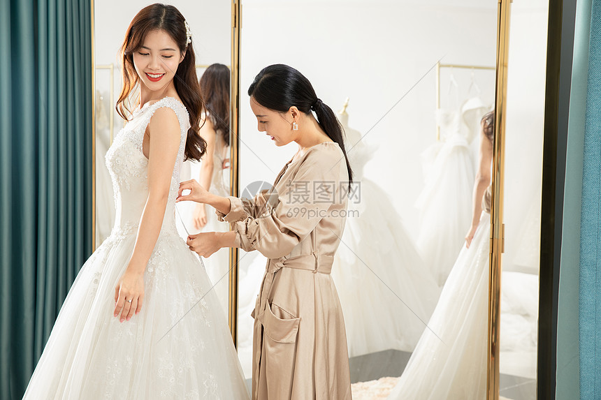 在镜子前试穿婚纱的准新娘图片
