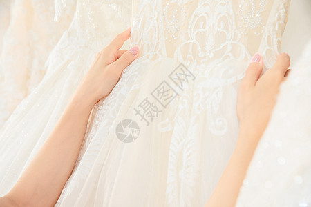 在婚纱店精心挑选婚纱的女孩特写图片