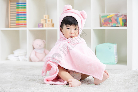 幼儿宝宝裹着浴巾在地毯上嬉戏图片