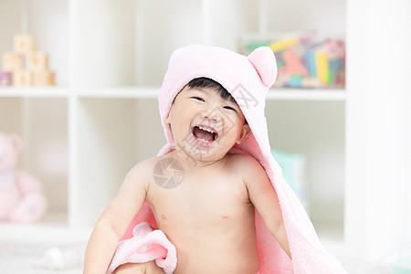 幼儿宝宝裹着浴巾在地毯上嬉戏图片