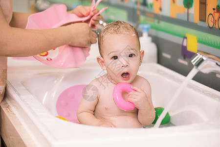 阿姨给婴幼儿洗澡特写图片