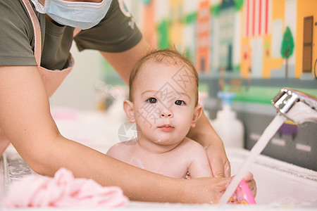 阿姨给婴幼儿洗澡特写背景图片