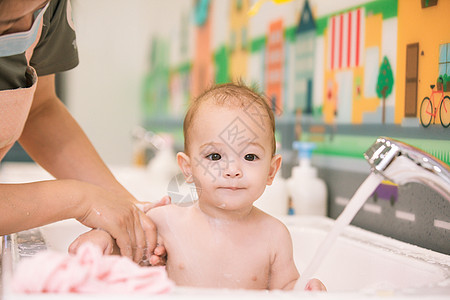 阿姨给婴幼儿洗澡特写背景图片