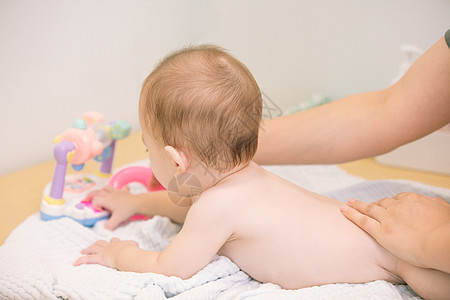 可爱宝宝洗澡后擦身体乳液背景图片